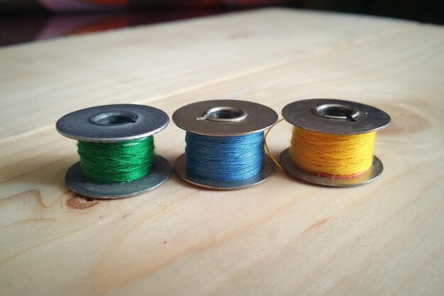 Primer plano de bobinas de hilo de varios colores en la mesa
