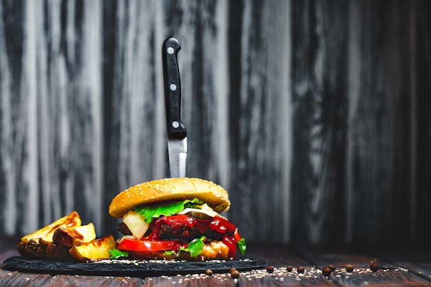 Primer plano de la boca agua, deliciosas hamburguesas caseras con un kni