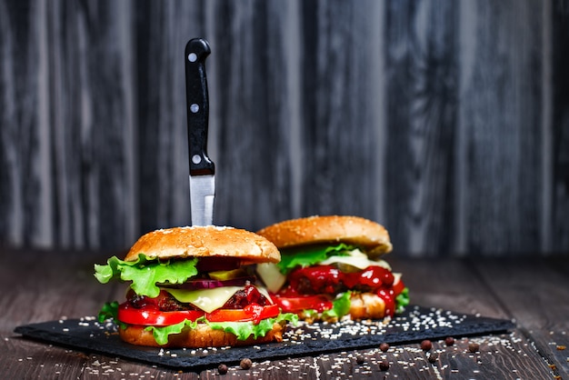 Primer plano de la boca agua, deliciosas hamburguesas caseras con un kni