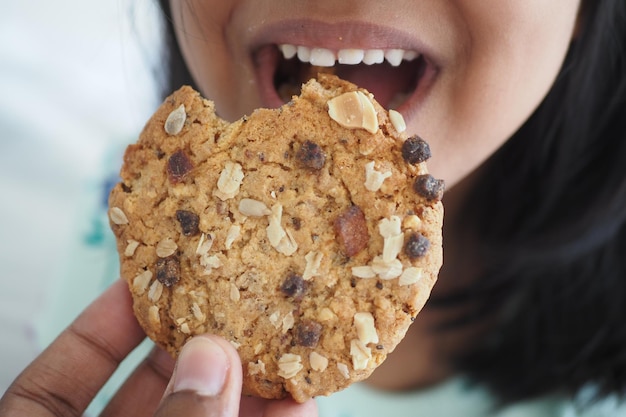 Foto primer plano de la boca de un niño comiendo galletas de comida entera