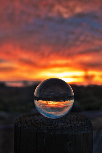 Primer plano de una bola de cristal contra el cielo durante la puesta de sol