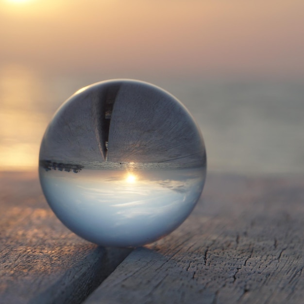 Foto primer plano de una bola de cristal en la mesa contra el cielo durante la puesta de sol