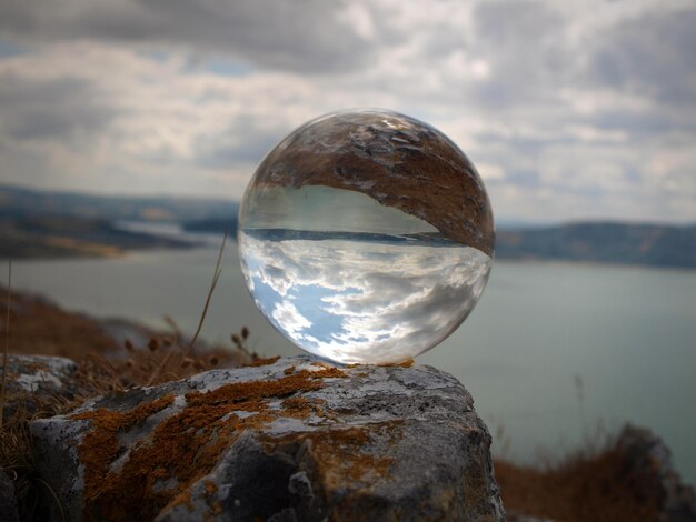 Foto primer plano de una bola de cristal en una roca contra el cielo