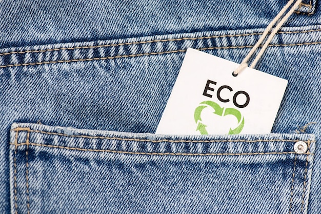 Primer plano de un bolsillo de jeans con un icono de reciclaje en la etiqueta Tejido reciclado de algodón orgánico