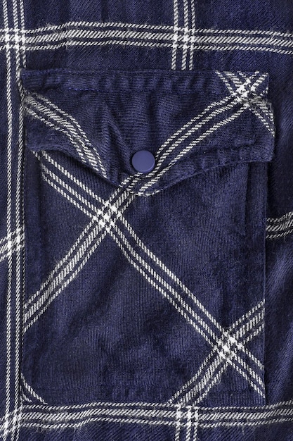 Primer plano de bolsillo con solapa de camisa de punto azul oscuro como fondo