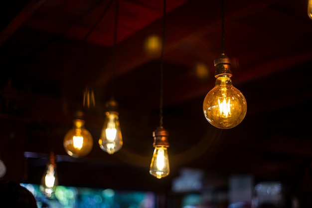 Foto primer plano de una bombilla iluminada colgando del techo