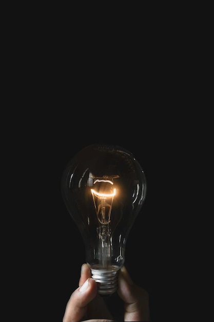 Primer plano de una bombilla iluminada contra un fondo negro
