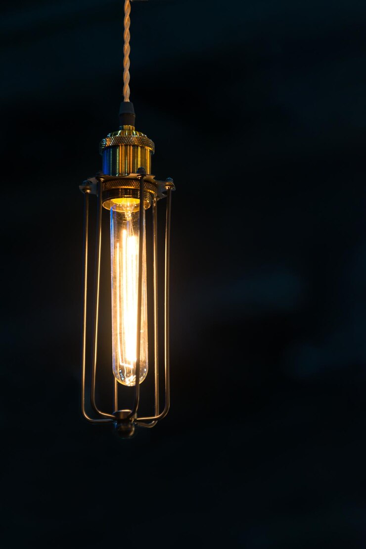 Foto primer plano de una bombilla iluminada contra un fondo negro