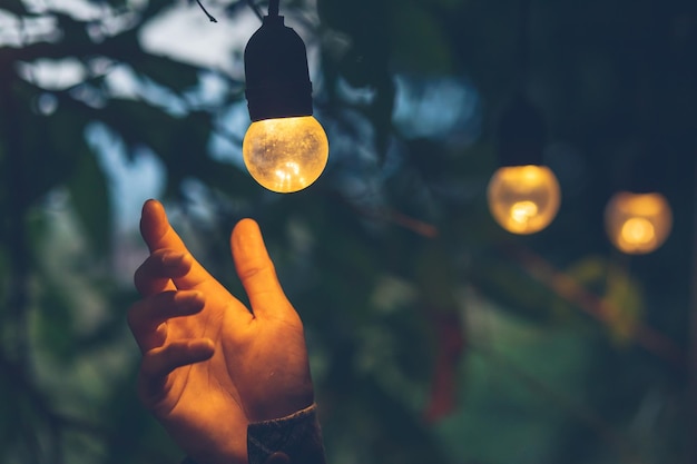 Primer plano de una bombilla iluminada en la mano