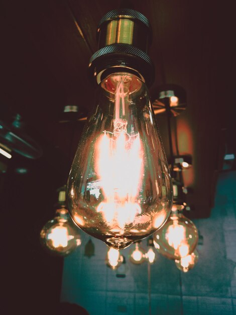 Foto primer plano de bombillas iluminadas colgando del techo