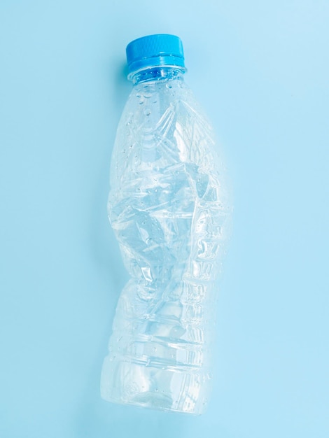 Foto primer plano de una botella de agua contra un fondo azul