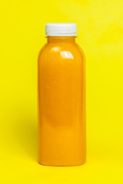 Foto primer plano de una botella amarilla contra un fondo naranja