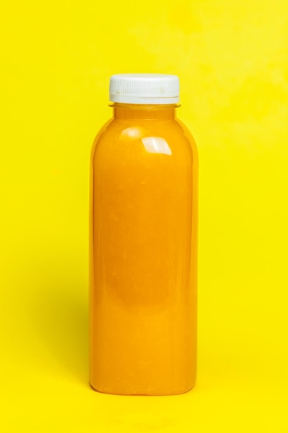 Primer plano de una botella amarilla contra un fondo naranja