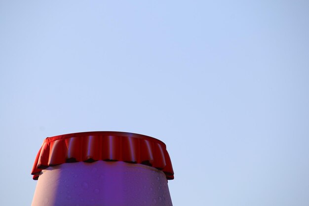 Foto primer plano de una botella de cerveza contra un cielo azul claro