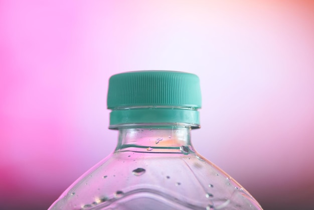 Primer plano de la botella contra un fondo rosado