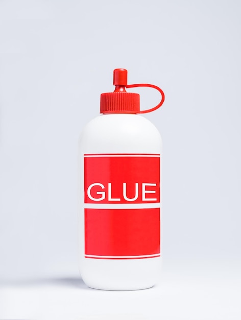 Primer plano de una botella de pegamento contra un fondo blanco