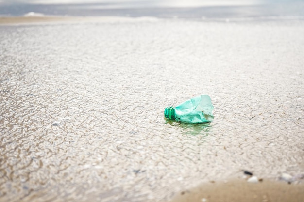 Foto primer plano de una botella en la playa