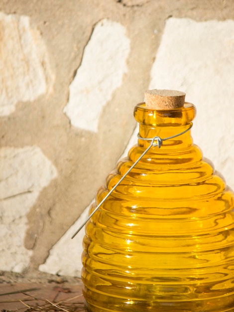 Primer plano de una botella de vidrio amarillo contra la pared