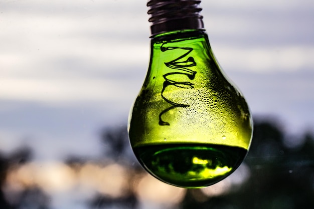 Primer plano de una botella de vidrio húmeda contra el cielo