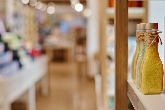 Foto primer plano de botellas con sal de baño de pie en el estante en una fila en la tienda