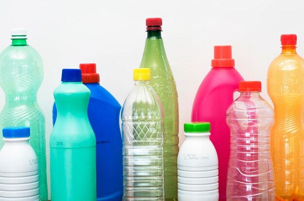 Primer plano de botellas de varios colores contra un fondo blanco