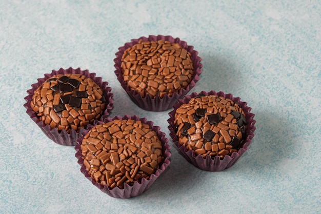 Primer plano de brigadeiros tradicionales y amargos sobre un fondo azul claro