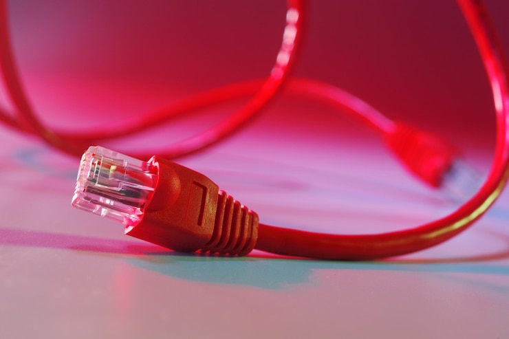 Foto primer plano de un cable rojo contra un fondo de color