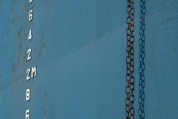 Foto primer plano de una cadena colgada contra la pared del barco
