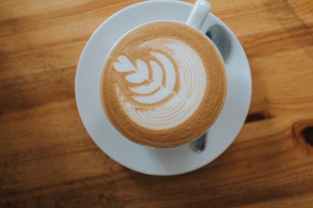 Primer plano de café con arte latte en la mesa
