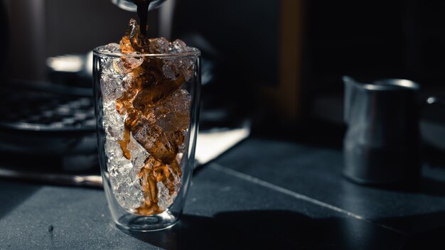 Primer plano de café helado servido en la mesa negra en el café