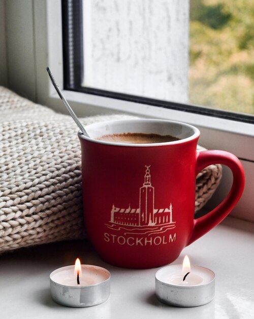 Foto primer plano de café y luz de té encendida en el alféizar de la ventana