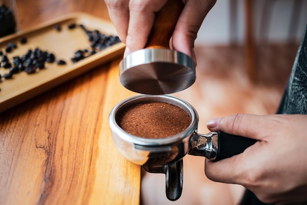 Foto primer plano de una cafetería barista manual haciendo café con prensas manuales café molido usando manipulación
