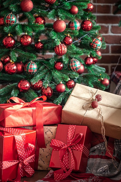 Primer plano de cajas de regalo rojas cerca del árbol de navidad