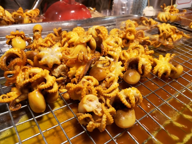 Primer plano de calamares en la barbacoa en el mercado nocturno