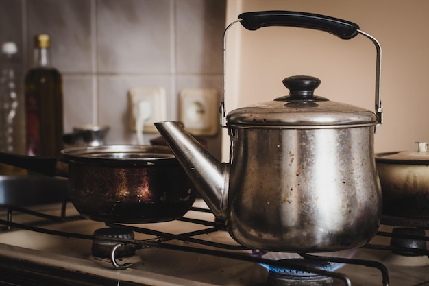 Foto primer plano de la calefacción de la tetera en el quemador en la cocina en casa