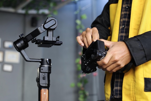 Primer plano de la cámara DSLR y el estabilizador de cardán en manos masculinas Concepto de videografía y cine