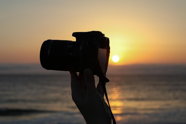 Foto primer plano de la cámara en la playa contra el cielo durante la puesta de sol