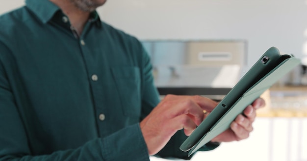 Primer plano de una camarera joven que usa una tableta digital en el mostrador y recibe pedidos de los clientes en el café