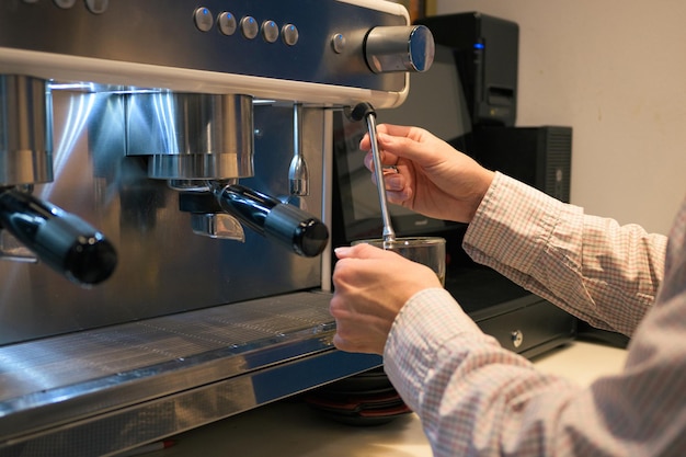 Primer plano de un camarero en una máquina de café