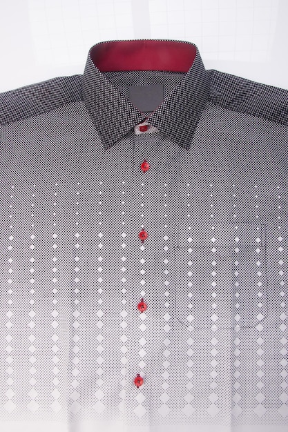 Foto primer plano de una camisa gris con botones hacia abajo contra un fondo blanco