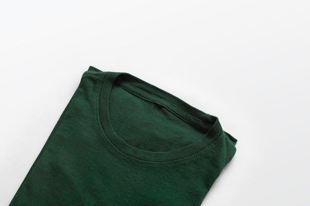 Primer plano de camiseta verde oscuro doblada con fondo blanco