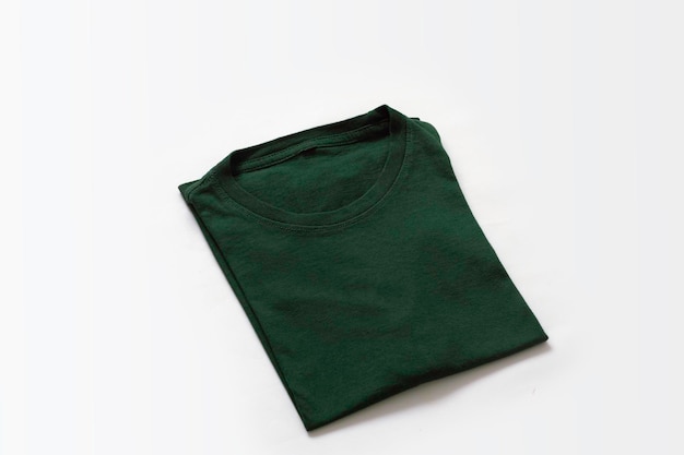 Foto primer plano de camiseta verde oscuro doblada con fondo blanco