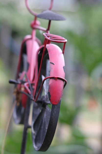 Primer plano de una campana rosa colgada en una planta en el patio