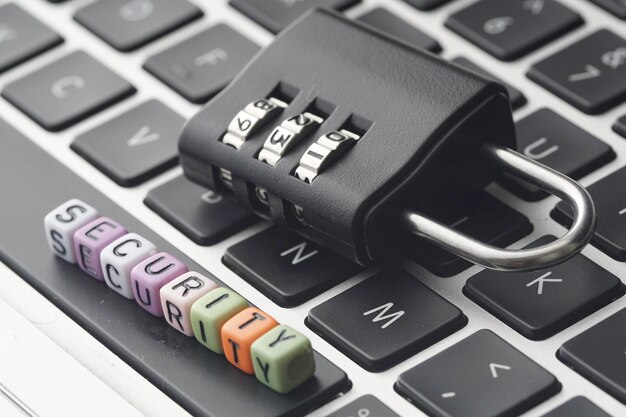 Primer plano de un candado con cuentas con texto en el teclado de la computadora