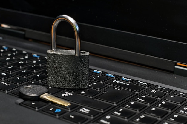 Primer plano del candado y la llave en el teclado de la computadora portátil