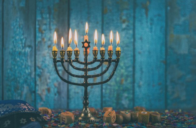 Primer plano de un candelabro de januca ardiendo con velas menorah