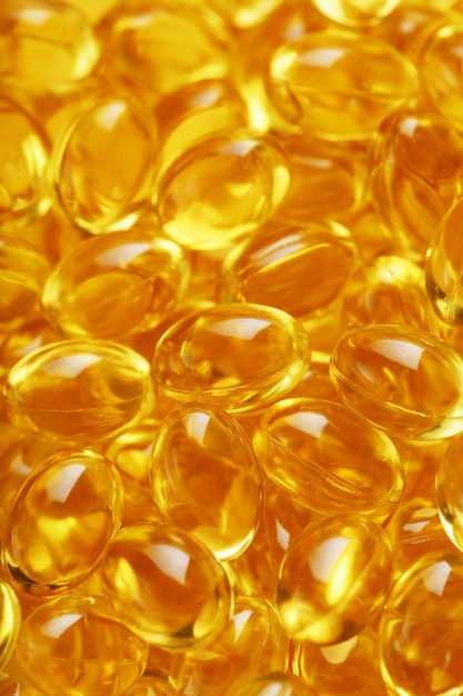 Primer plano de cápsulas de vitamina D3 dorada en pantalla completa La vitamina más importante en una forma líquida fácilmente digerible