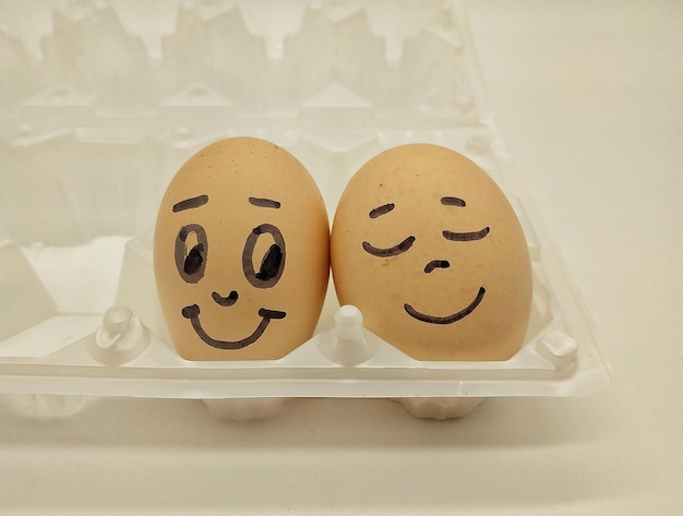 Primer plano de la cara antropomórfica sobre huevos en cartón contra un fondo blanco
