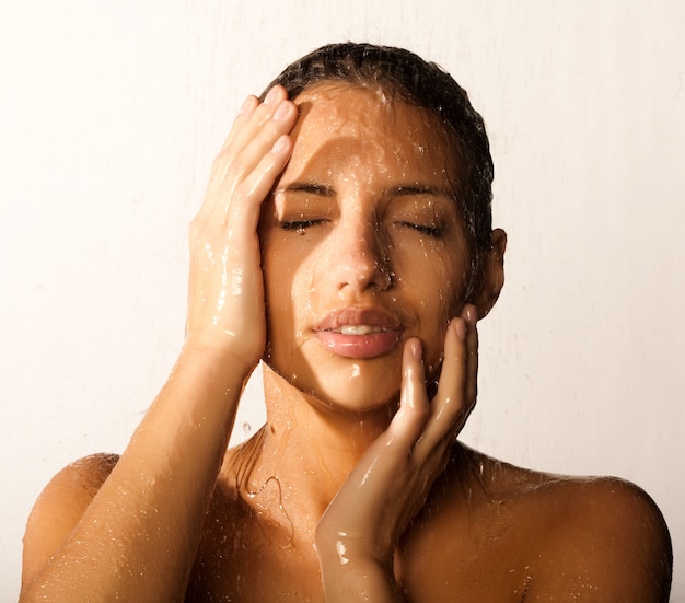 Primer plano de cara hermosa mujer mojada con gota de agua