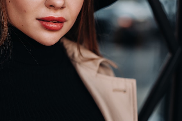 Primer plano de la cara y los labios de una niña con un abrigo beige.